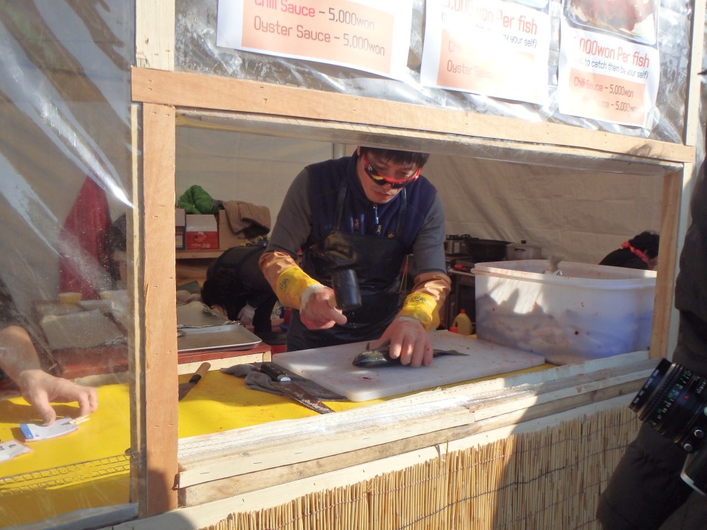 First you take your fish to this guy and pay. He pounds them in the head and scores them.